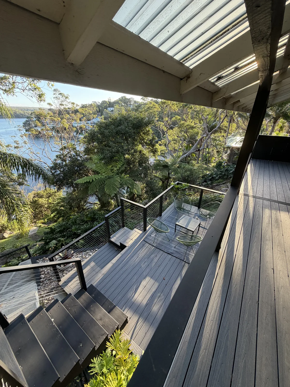Finished waterfront deck with glass balustrade and louvred roof